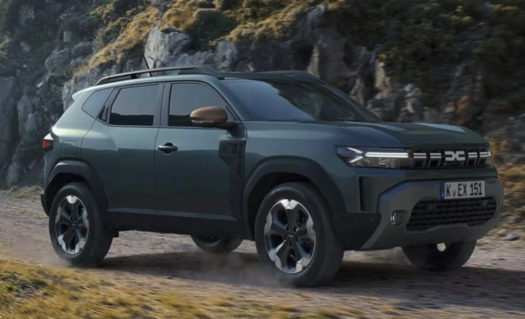 Dunkelgrüner Dacia Duster SUV auf einem Schotterweg vor felsiger Landschaft